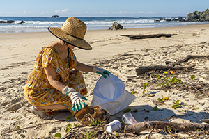 Lady cleaning up litter on a beach