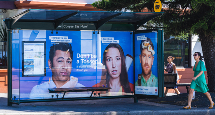 bus shelter showing the large Don't be a tosser characters with litter stuck to their heads