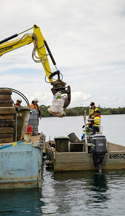 crane arm lifting debris off a boat