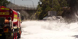 fire truck sprays burnt out truck with foam