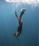 a diver with long flippers plunges downwards