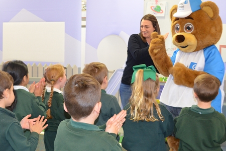 Large teddy Lead Ted junior character talking to school children