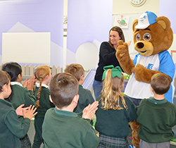 large bear character Led Ted Junior interacting with school children