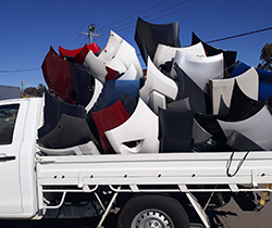 large pile of recycled car bumper bars on the back of a ute