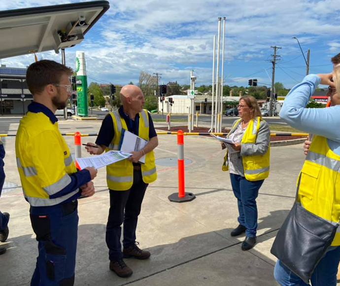 people in hi viz and clipboards at an inspection at a petrol station 