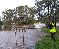 EPA inspector in hi vis vest at the flooded Moruya River