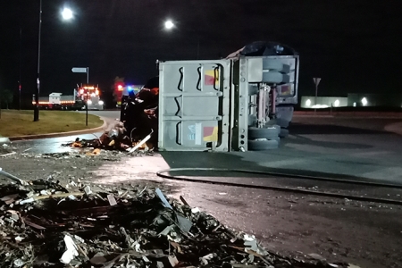 overturned truck spilling asbestos waste onto the road