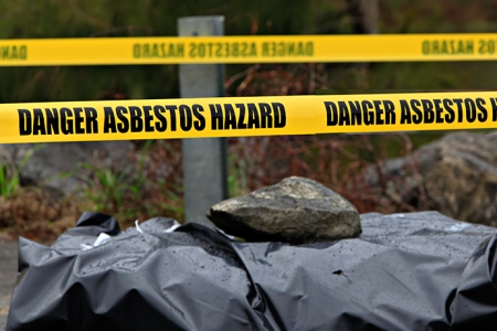 asbestos warning tape around dumped asbestos waste