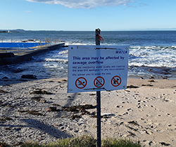 warning sign on sewerage contamination on beach