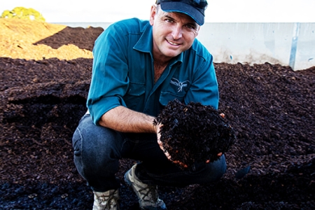 industry worker handling composted soil