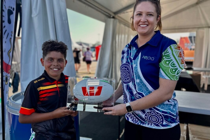 Young boy at Koori Knockout chats with EPA officer