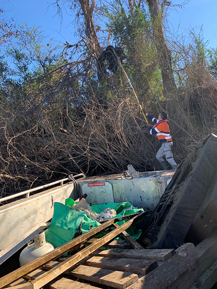 Contractor removing flood debris from trees along the Hawkesbury River, after the 2021 floods