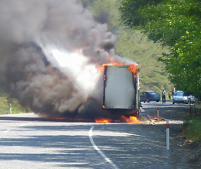 smoke billows out of a truck which is on fire