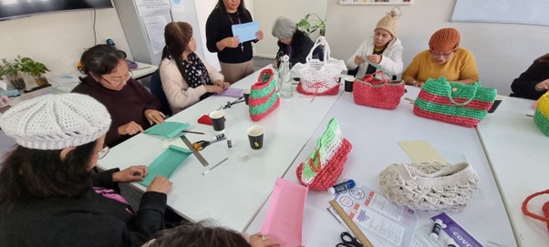 Group of people at Addison Road, making bags from plastics