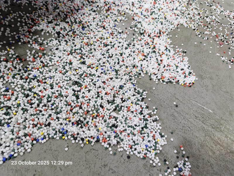 Plastic pellet pollution shown on the ground.