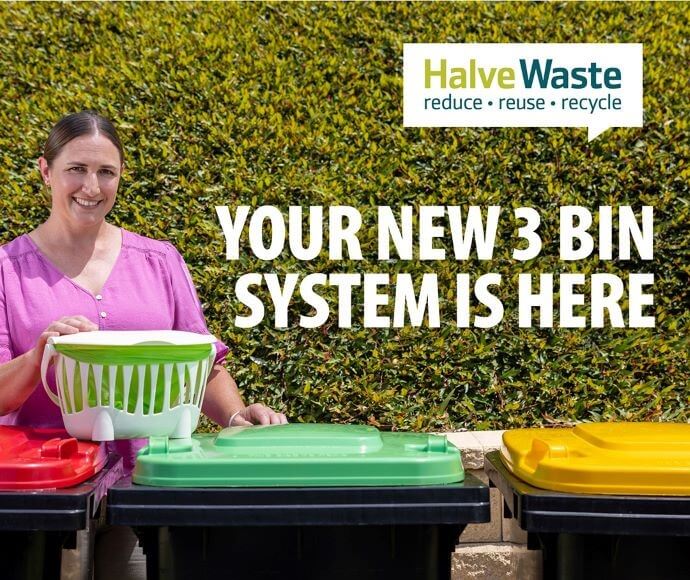Woman standing near three bins